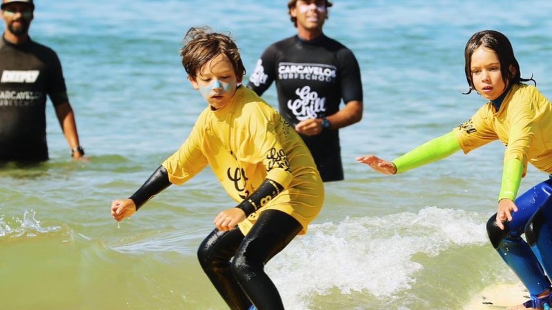 a couple of people that are surfing in the ocean