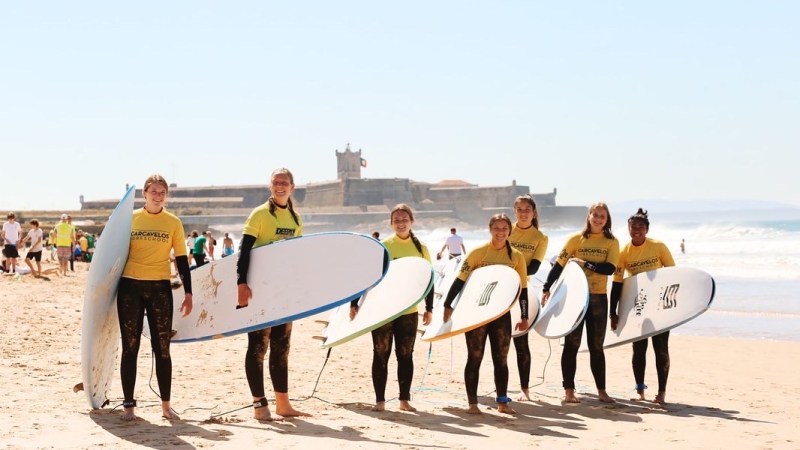 a group of people standing on a beach posing for the camera