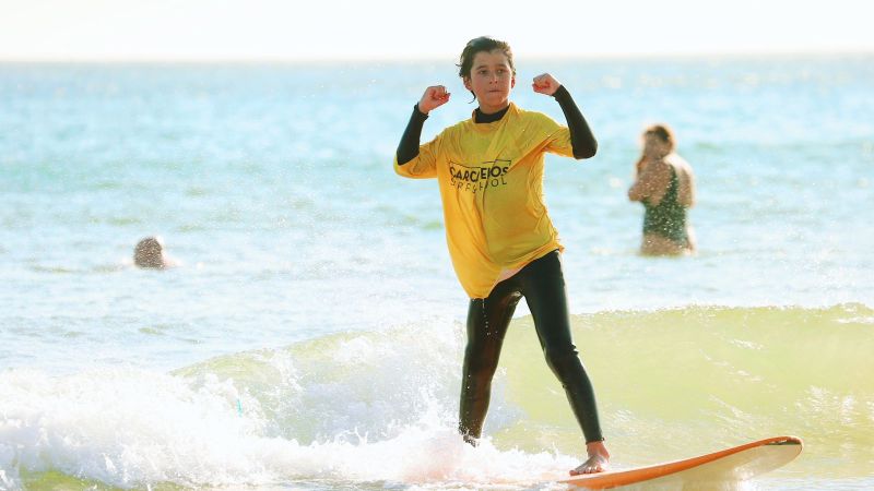 a person riding a wave on a surf board on a body of water