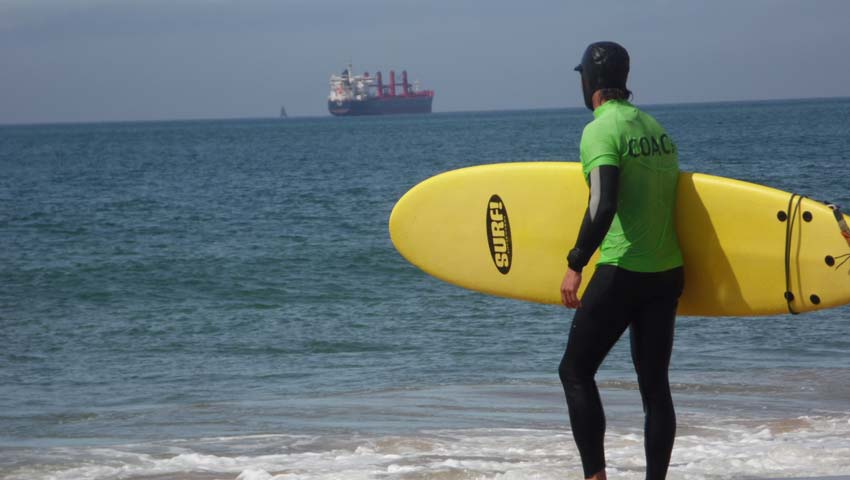 a man carrying a surf board on a beach