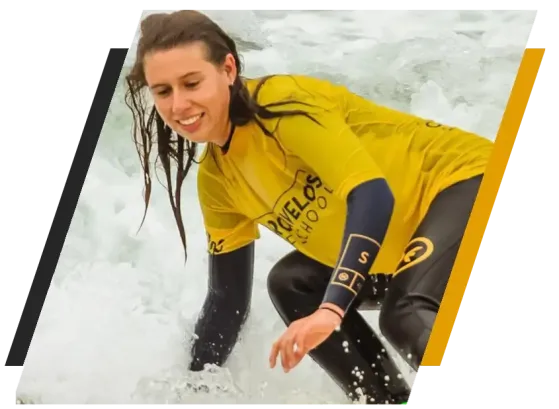 Woman in yellow wetsuit surfing on white waves.