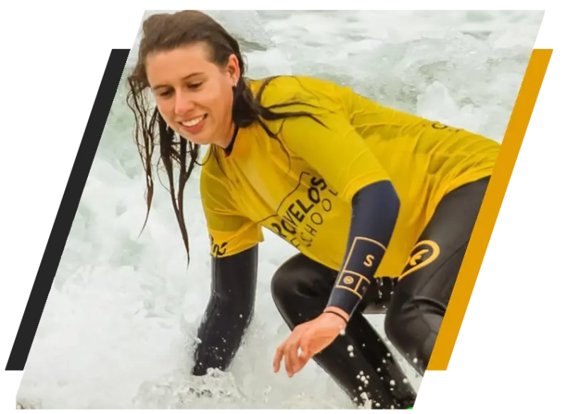 Woman in yellow wetsuit surfing on white waves.